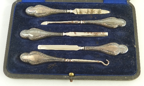 An Edwardian five piece manicure set, having baluster shaped hafts embossed with harebells in