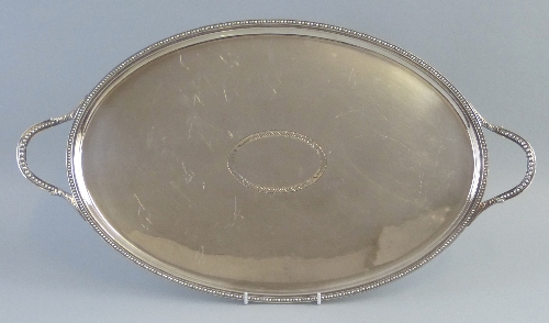 A tea tray, of oval form with central blank cartouche, beaded rim and leaf capped beaded loop