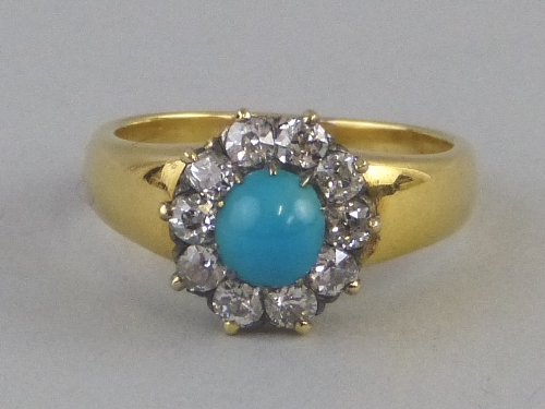 A turquoise and diamond cluster ring, comprising a central cabouchon turquoise surrounded by claw