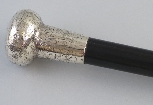 An early 20th Century walking cane, the ebonised shaft with chased silver terminal, hallmarked