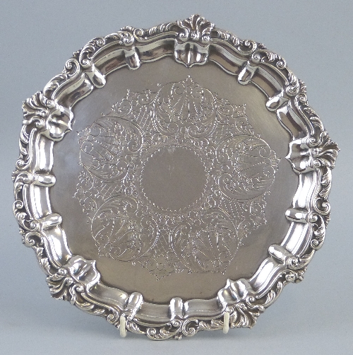 A late 19th Century salver, of circular form with blank central cartouche on scrolling leaf ground