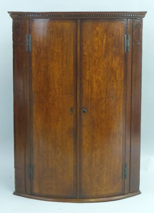 A George III oak quadrant corner cupboard, with satinwood and ebony stringing, wall hanging having