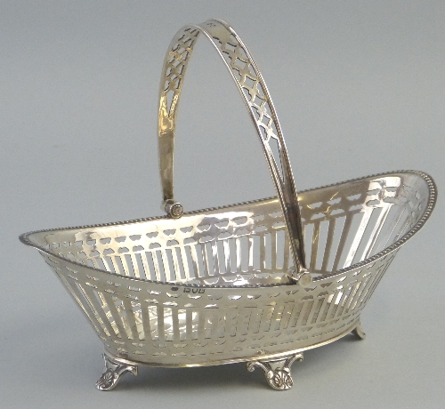 An Edwardian fruit basket, of boat form with pierced swing loop handle having trellis pierced sides