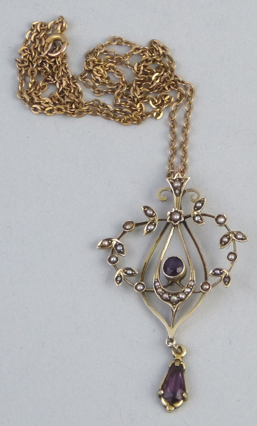 An Edwardian amethyst and seed pearl pendant, of pierced wire work form having central amethyst