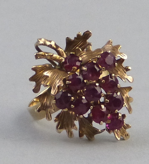 A ruby ring, comprising numerous stones claw set as a bunch of grapes with yellow metal leaves on