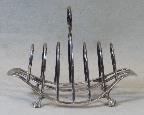 A late Victorian toast rack, of oval dished form with seven arched divisions having central ring