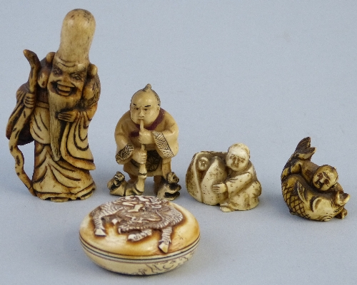 A Japanese ivory netsuke, carved as a man playing a horn with a rat emerging from the trumpet end,