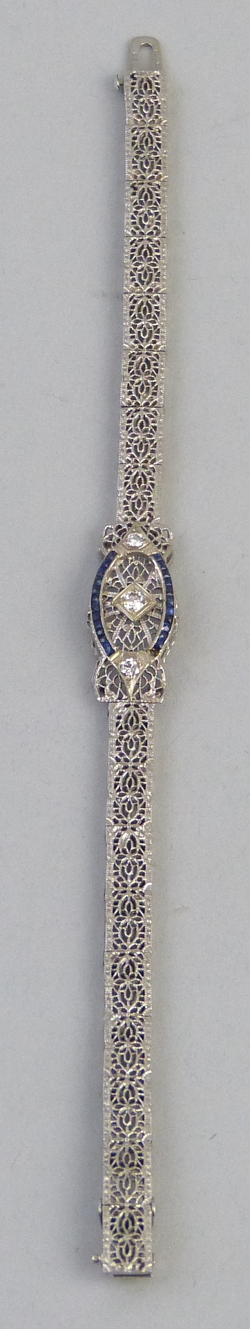 An Art Deco style sapphire and diamond bracelet, having central panel set with three diamonds within