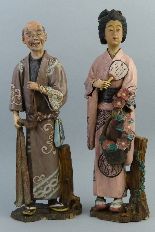 A pair of Japanese glazed earthenware figures, one as a geisha girl standing wearing a pink and