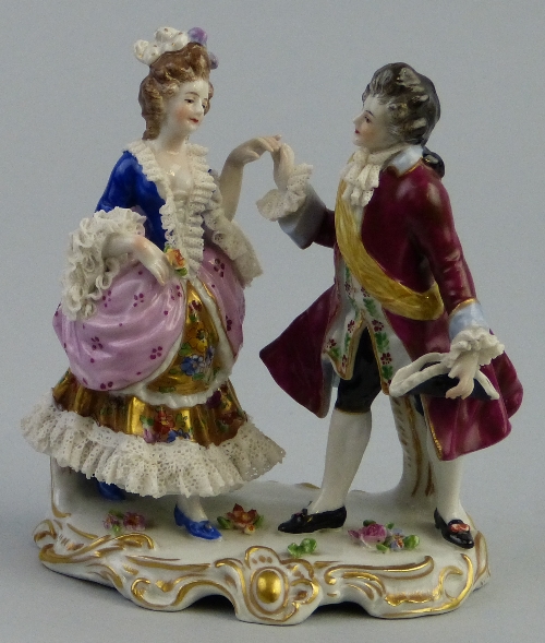 A Continental group, of a man and woman dancing in 18th Century costume on a gilded scrolling