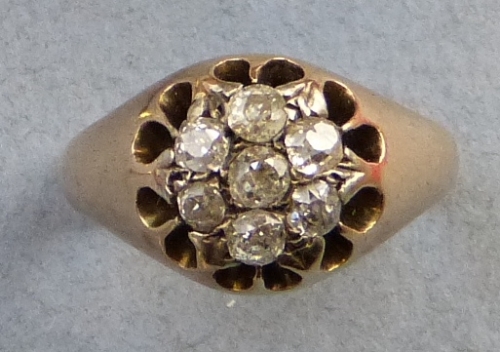 A diamond cluster ring, comprising seven old cut stones set on a yellow metal shank, size L