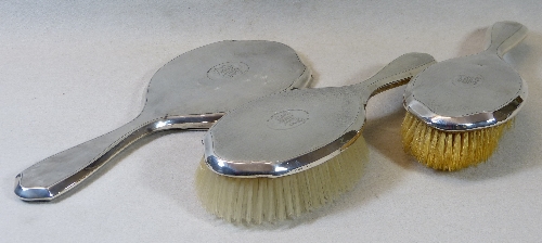 A matched three piece dressing table set, comprising two hair brushes and a hand mirror with