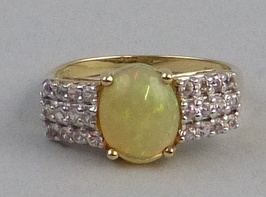 An Indonesian opal and white sapphire ring, comprising a central oval opal panel on 9ct gold shank