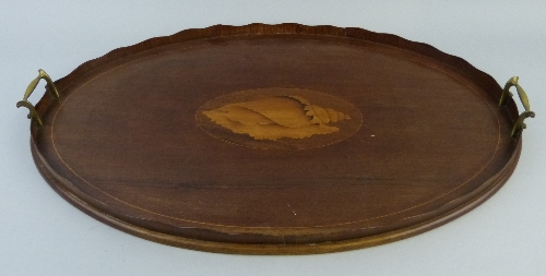 An early 20th Century mahogany tray, of oval form with undulating gallery, central marquetry panel