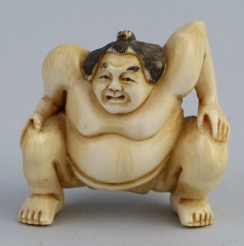 A Japanese ivory netsuke, carved as a squatting sumo wrestler, signed, 4.5cm high