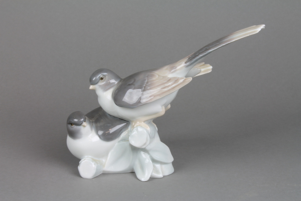 A Lladro group of 2 birds on a rustic base 9