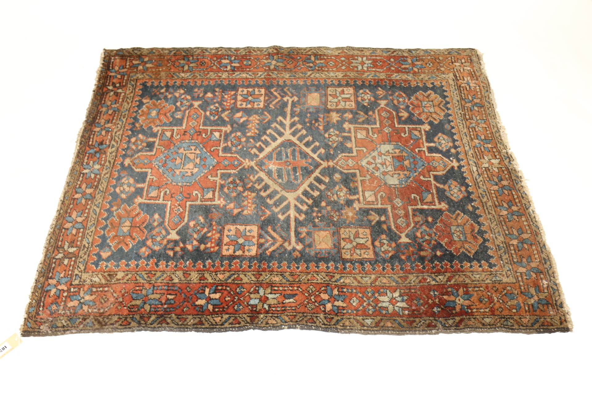 AN EARLY 20TH CENTURY CAUCASIAN RUG, blue ground with central latch-key diamond & three outer