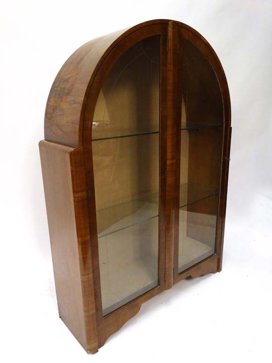 1950's Art Deco : a walnut arch shaped display cabinet with two doors and two glass shelves