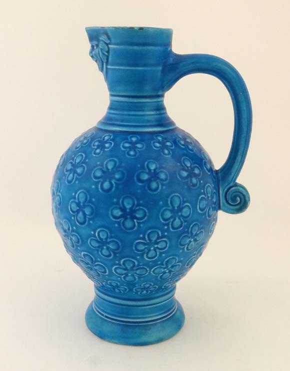 A 19th turquoise blue glazed ewer by Minton having a smiling mask head spout ribbed neck and