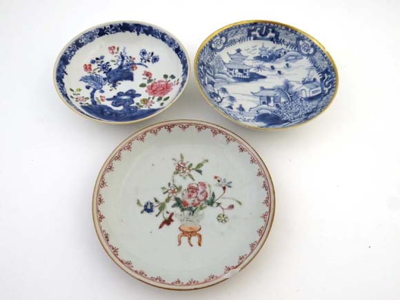 Three Chinese saucer dishes : a blue and white decorated saucer with gilt rim , a puce and poly