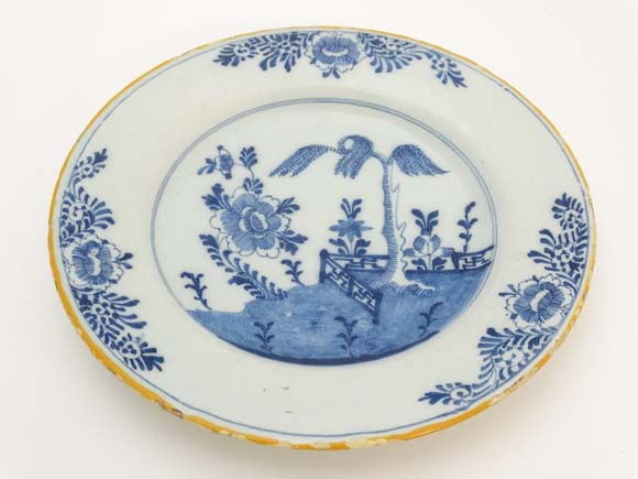 Delft : An early 18thC Dutch Delft plate , signed under , and with blue oriental garden pattern ,