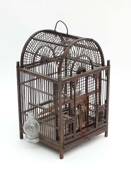 A c.1900 Oriental bird cage of domed building form with twin glass feeder / drinkers 10 1/4" wide