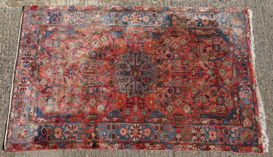 Rug Carpet : A signed Persian Heriz carpet , the rose madder field with a central blue medallion and
