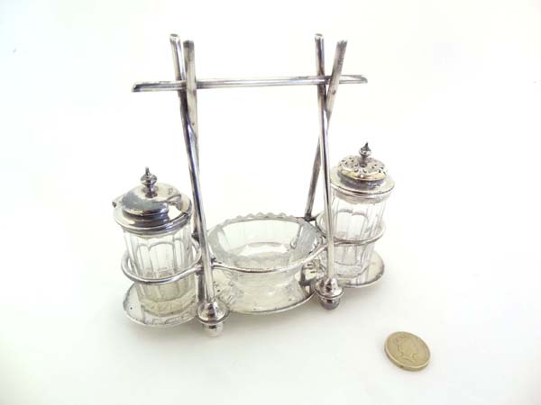 A Christopher Dresser inspired silver plate cruet stand with salt, pepper and mustard pot . The