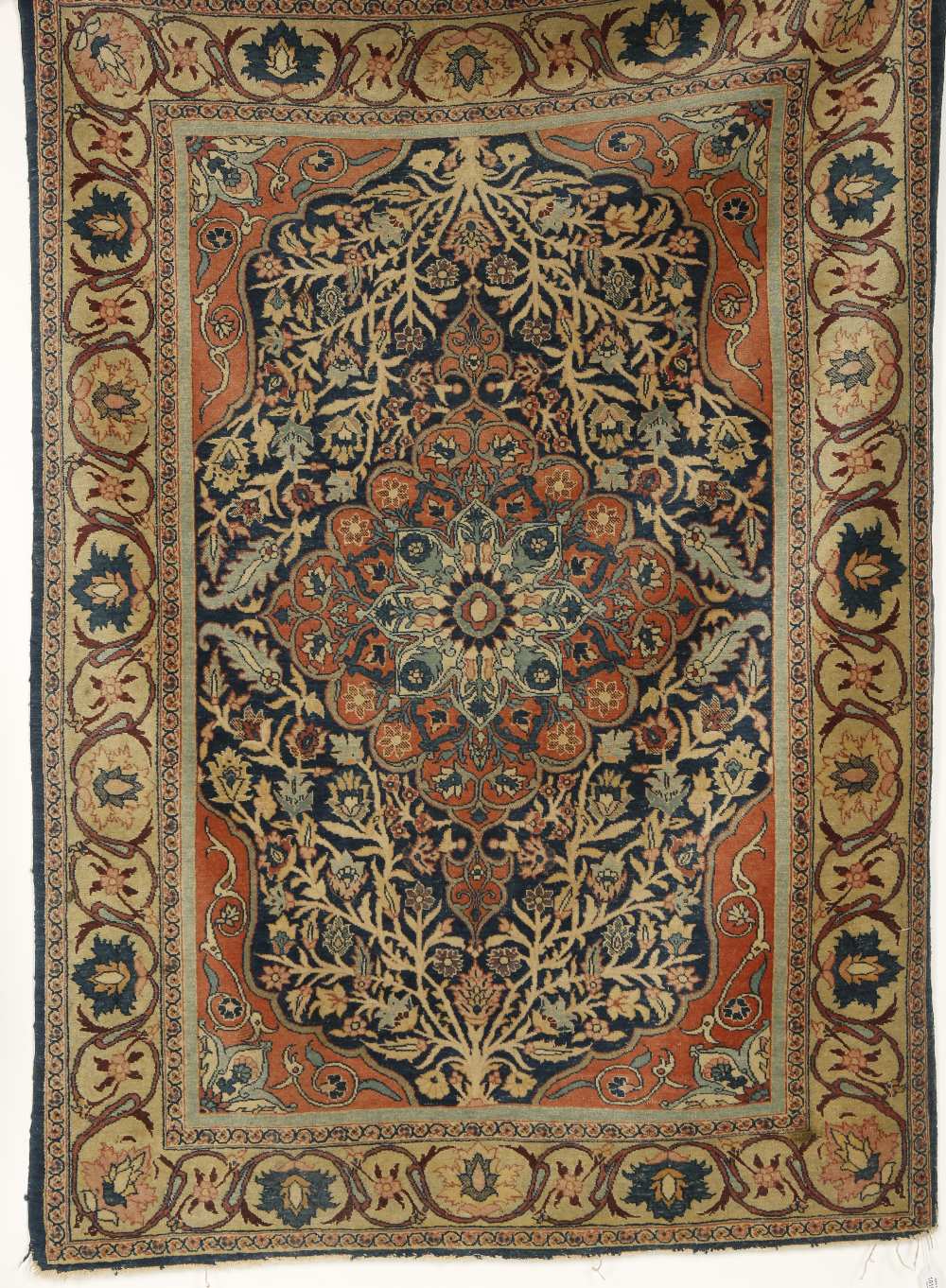 A PERSIAN RUG worked with a central scrolling foliate medallion with stylised flowerheads and