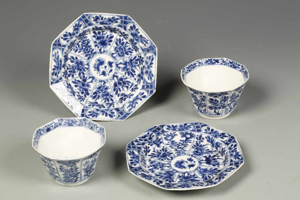 A PAIR OF CHINESE BLUE AND WHITE OCTAGONAL CUPS AND SAUCERS densely decorated with panels of