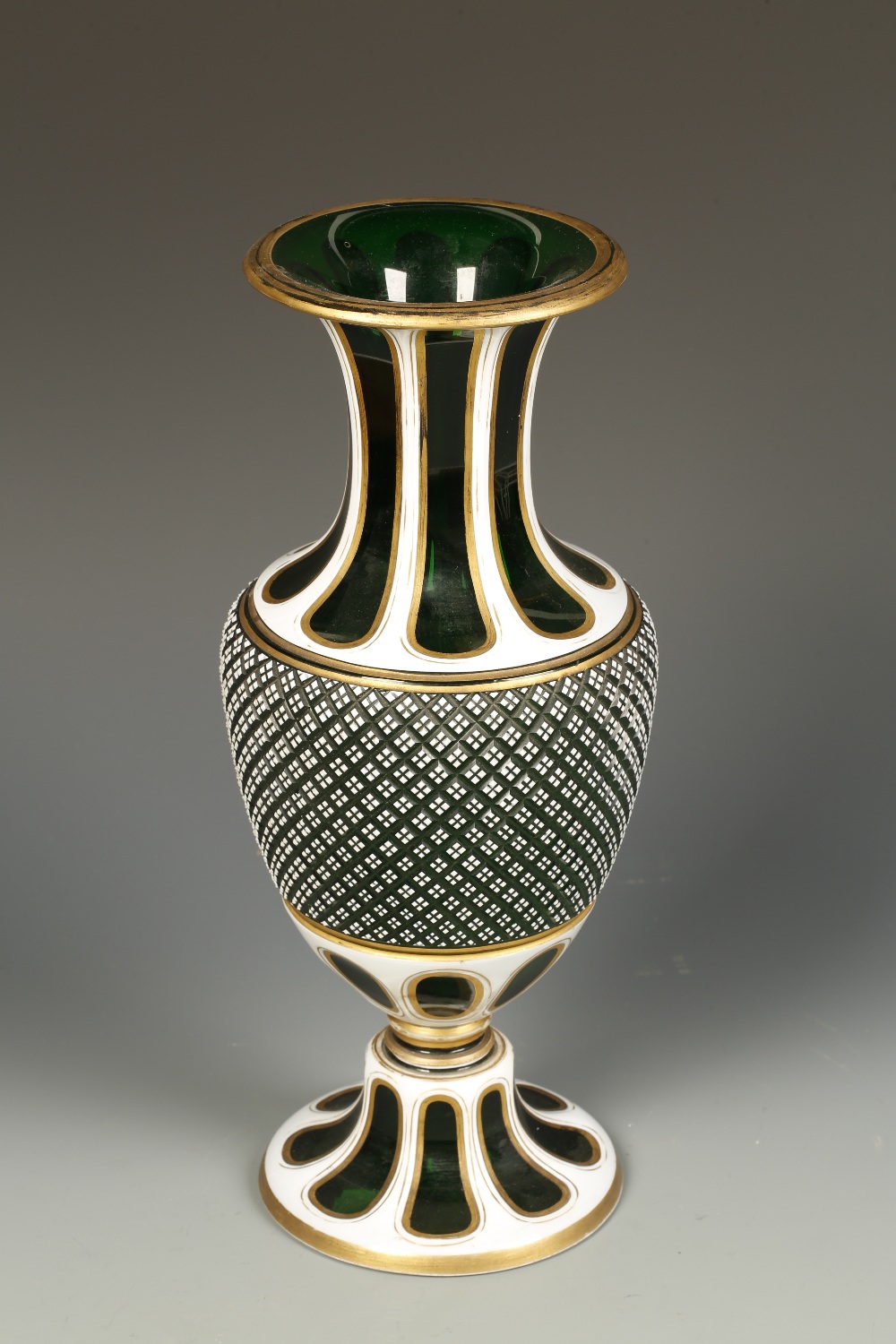 A BOHEMIAN GREEN AND WHITE OVERLAID VASE with gilt highlights, the baluster form vase with a narrow