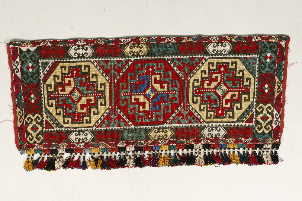 A CENTRAL ASIAN SILK POLYCHROME DOOR HANGING, the centre worked with three geometric medallions,