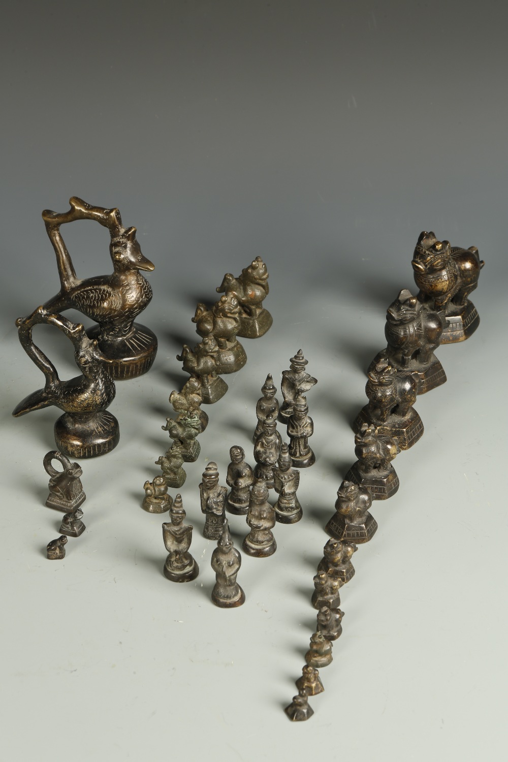 A GROUP OF BURMESE BRONZE ANIMAL-FORM WEIGHTS, most with mythical beast finials, two of bird-form