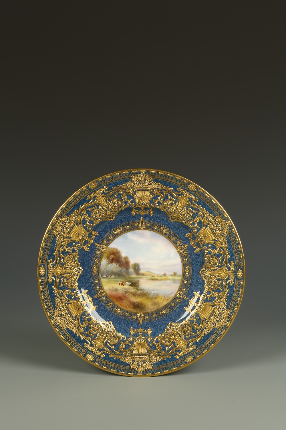 A ROYAL WORCESTER PLATE painted by Harry Stinton, painted to the centre with a scene of cattle