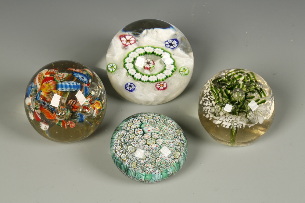 A GLASS PAPERWEIGHT with multi-coloured floral canes, against a lace effect ground, the base with