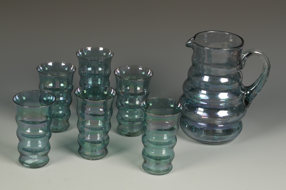 A WHITEFRIARS STYLE PALE GREEN GLASS LEMONADE SET comprising a jug and six glasses of tapering