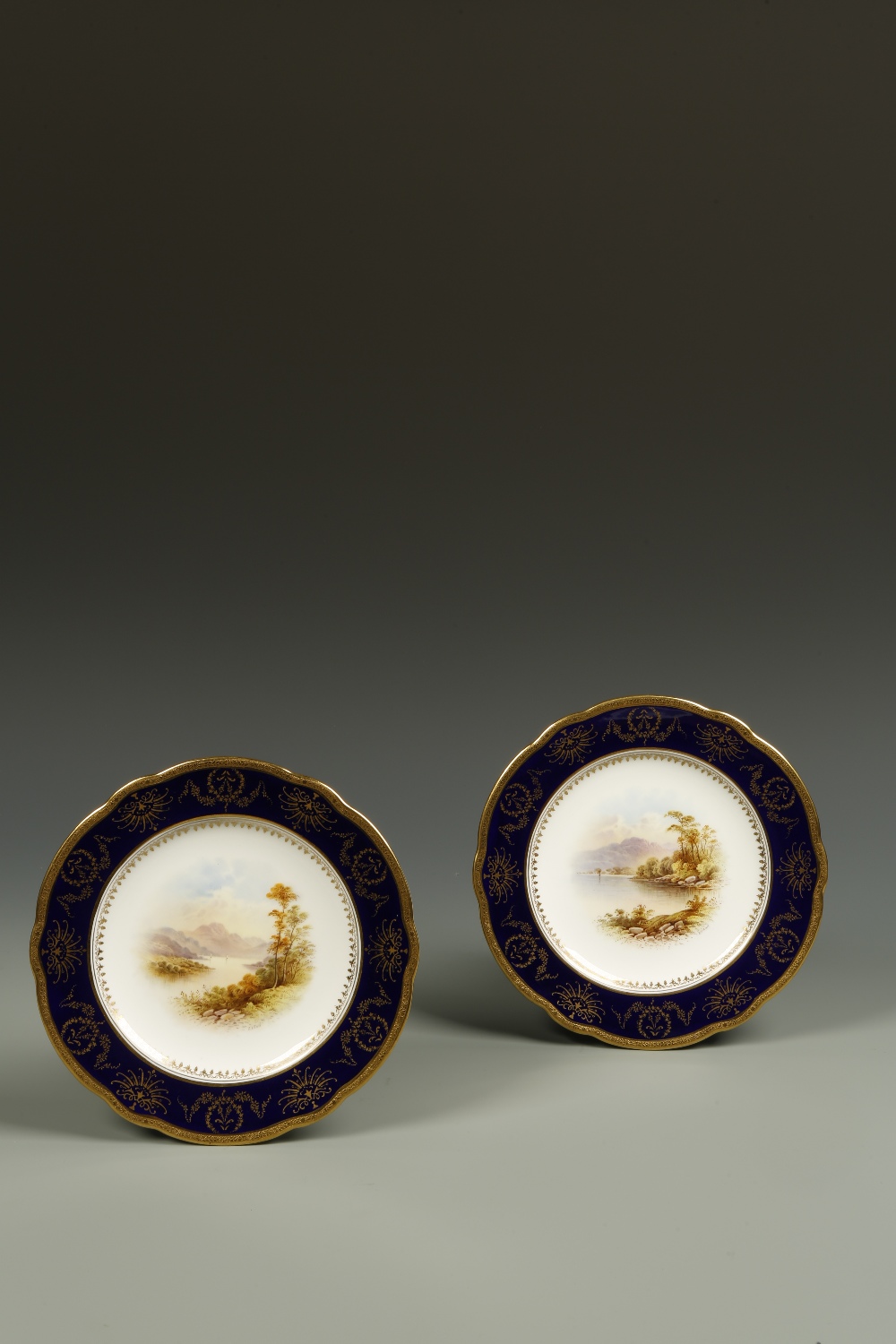 A PAIR OF COALPORT PORCELAIN PLATES, one painted with a scene of Loch Katrine, the other of Loch