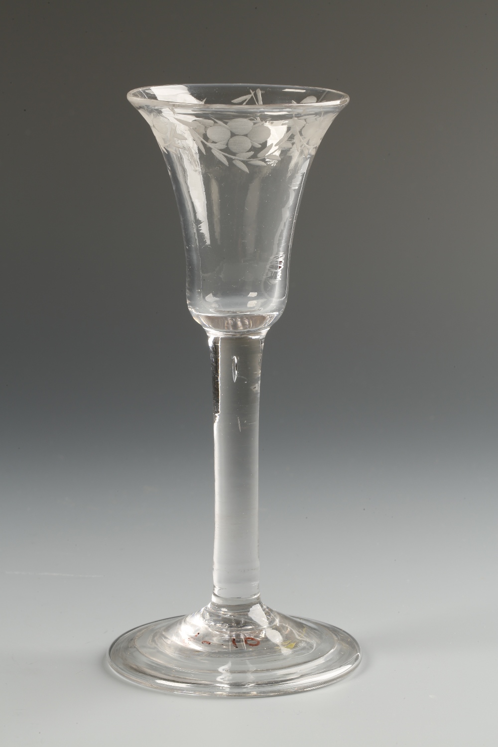 AN 18TH CENTURY WINE GLASS with a flared trumpet-shaped bowl etched with hanging swags to the rim,