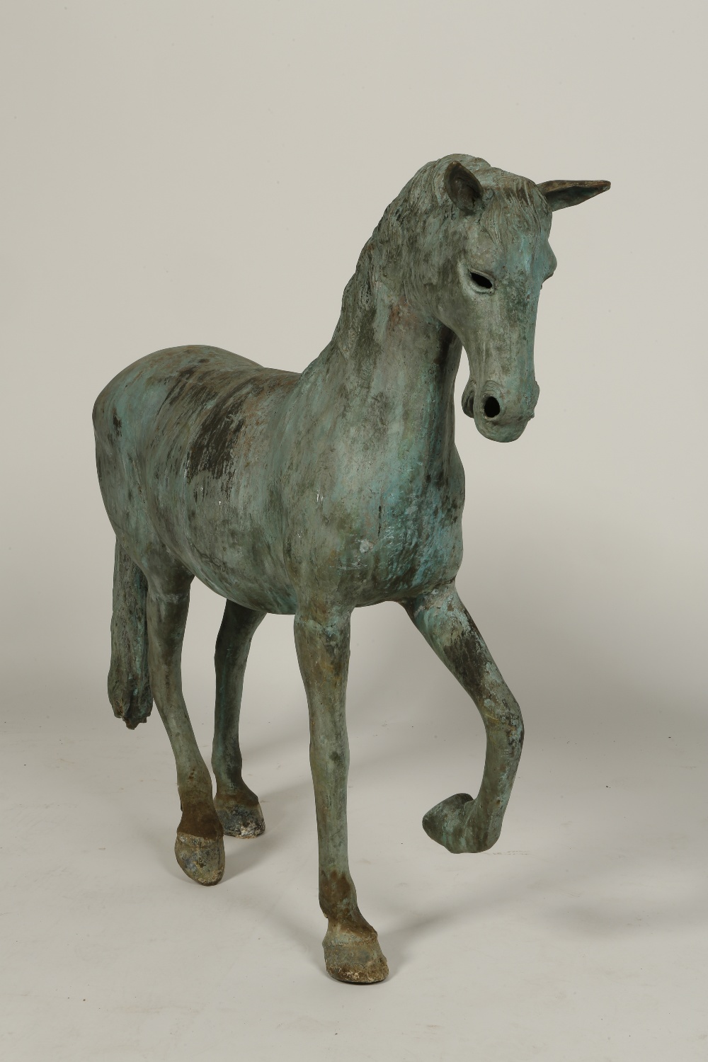 A CAST BRONZE STATUE OF A PRANCING HORSE with all over green patination, 36" high