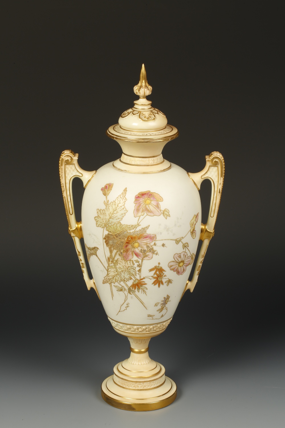 A ROYAL WORCESTER BLUSH IVORY VASE AND COVER of urn form, painted with pink flowers against a