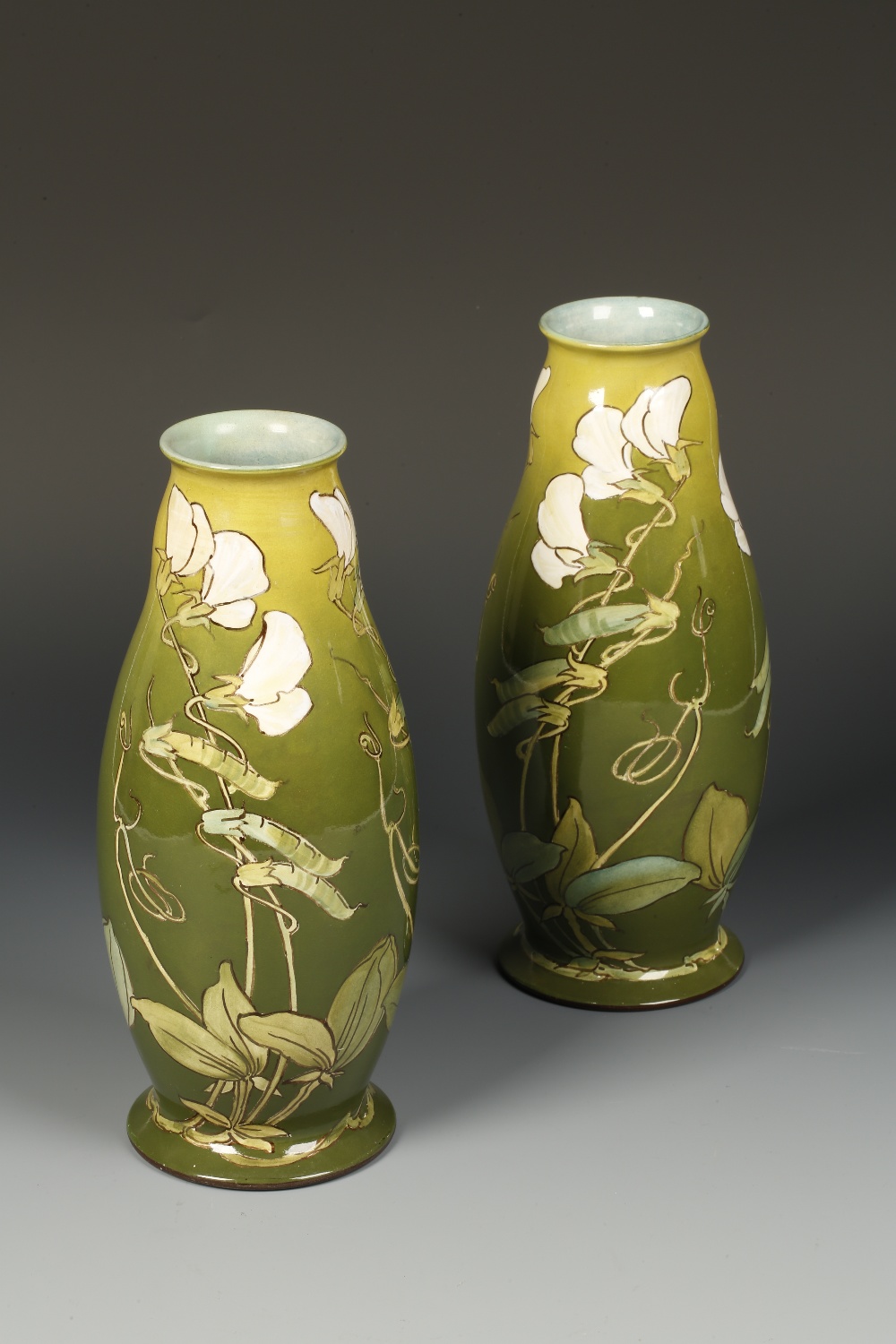 A PAIR OF DOULTON LAMBETH VASES of ovoid form, painted with white sweet peas against a graduated