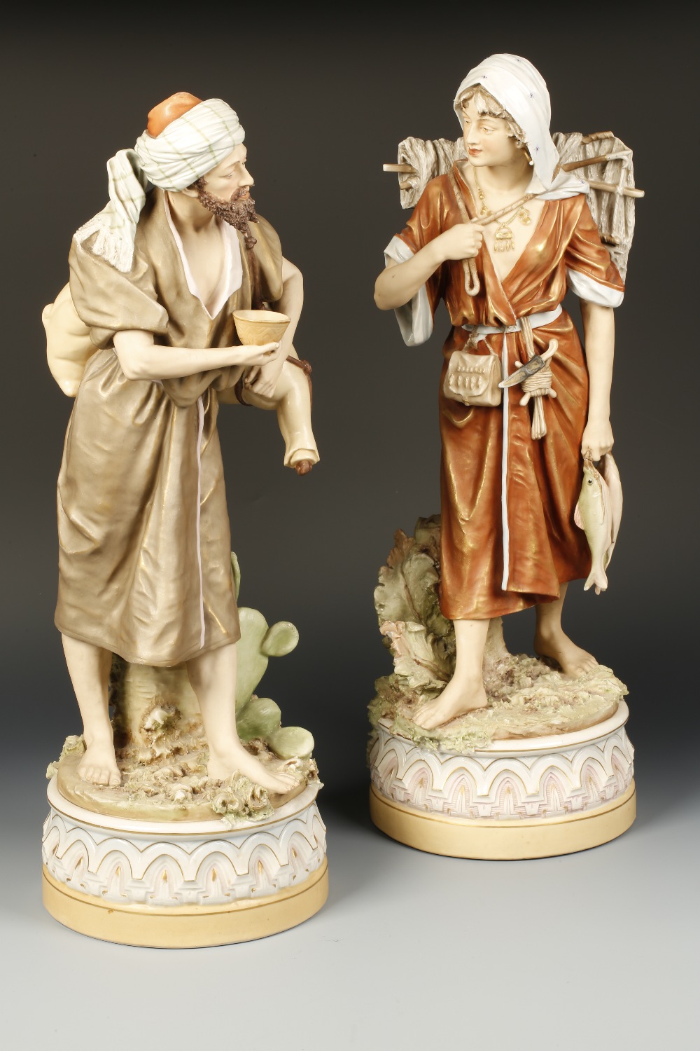 A PAIR OF LARGE ROYAL DUX FIGURES of an Arabian man carrying a bowl with flask on his back, the lady