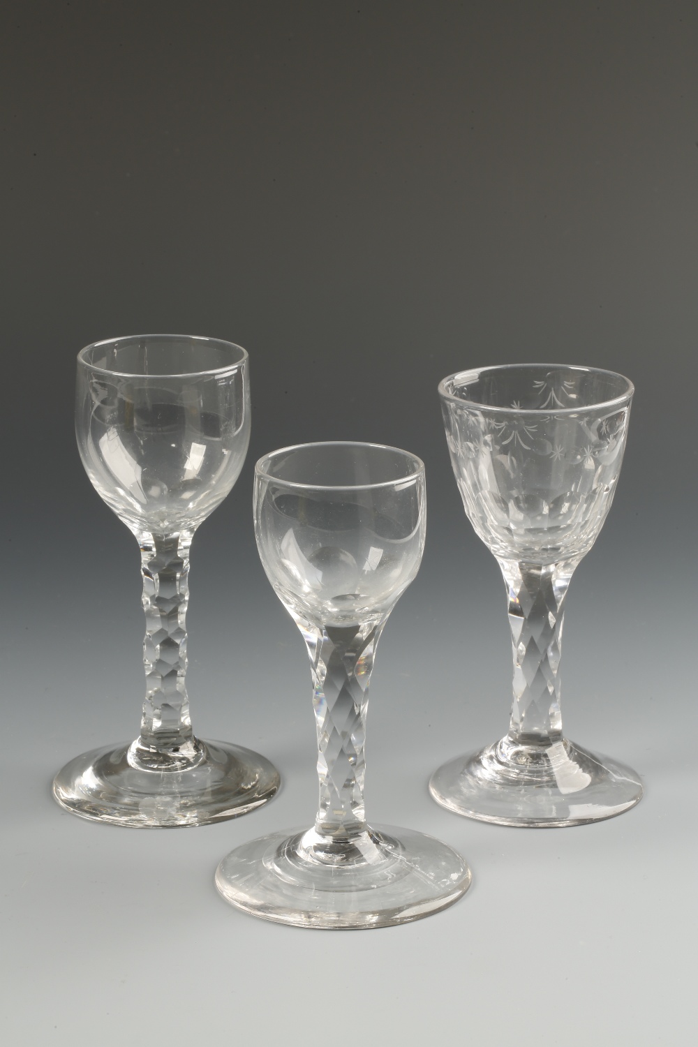 AN 18TH CENTURY WINE GLASS with faceted stem, the bowl with panel-cut base and egg and dart