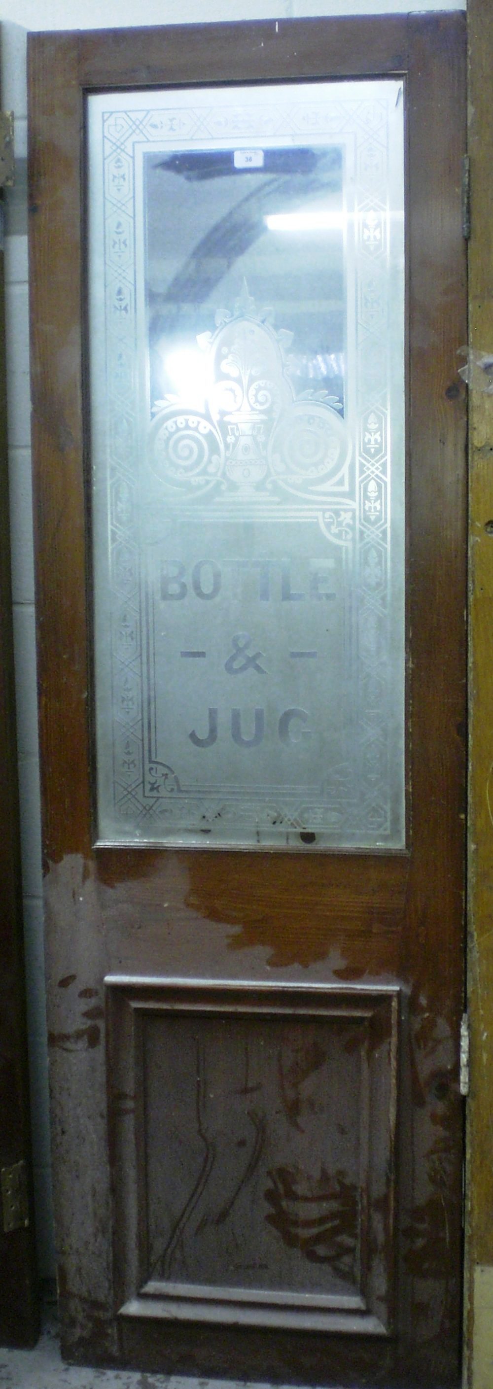 A Victorian pub door with large etched panel `Bottle and Jug` within a decorative border