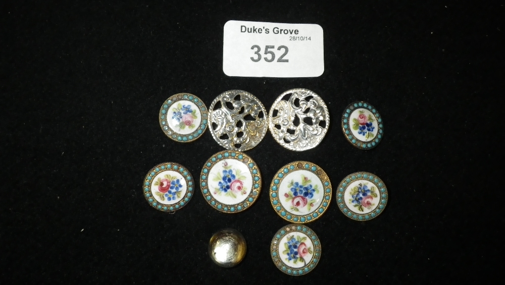 A collection of floral enamelled metal buttons and two silver examples