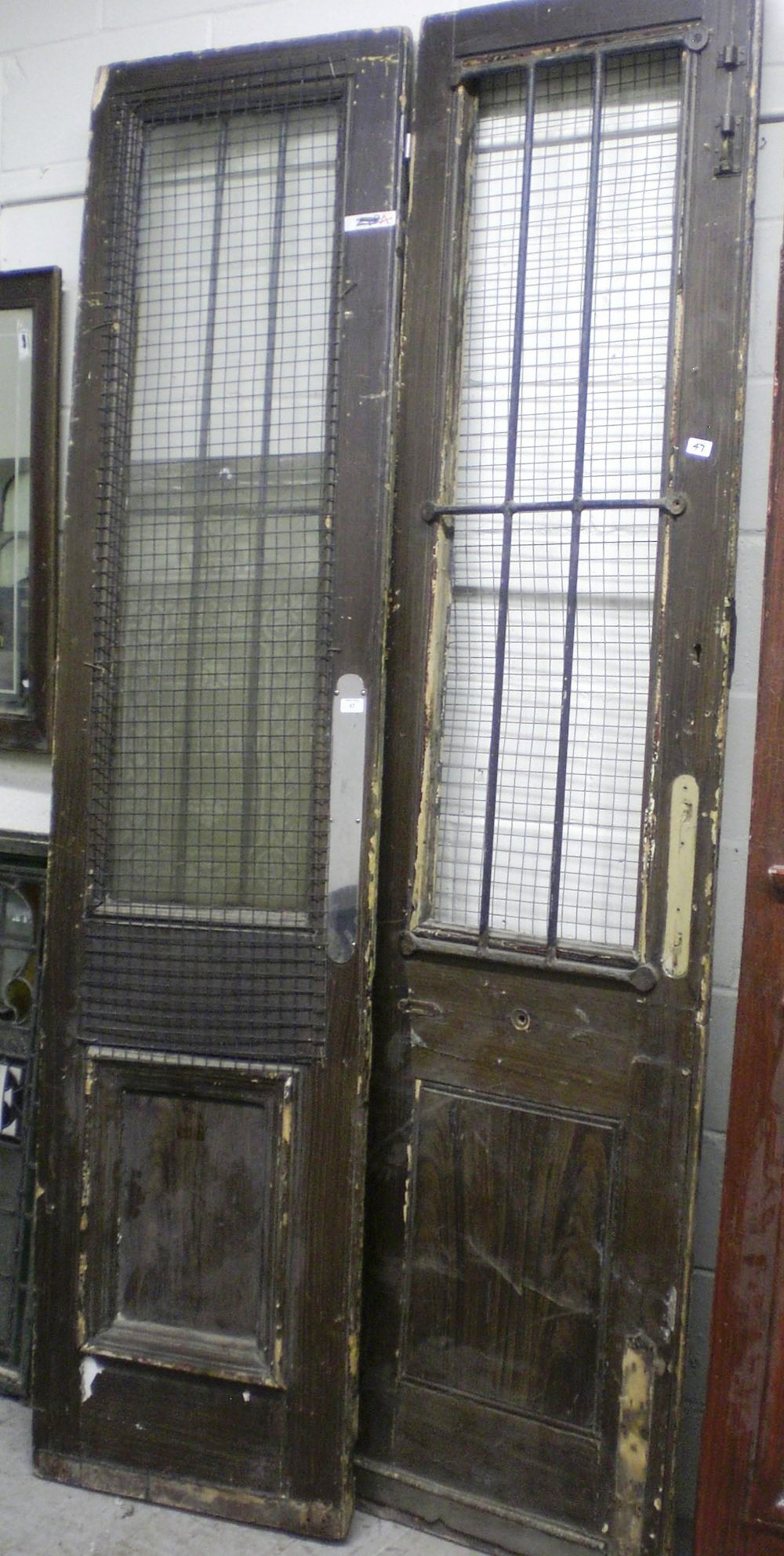 A pair of tall pub doors, one with an etched glass panel `Saloon`