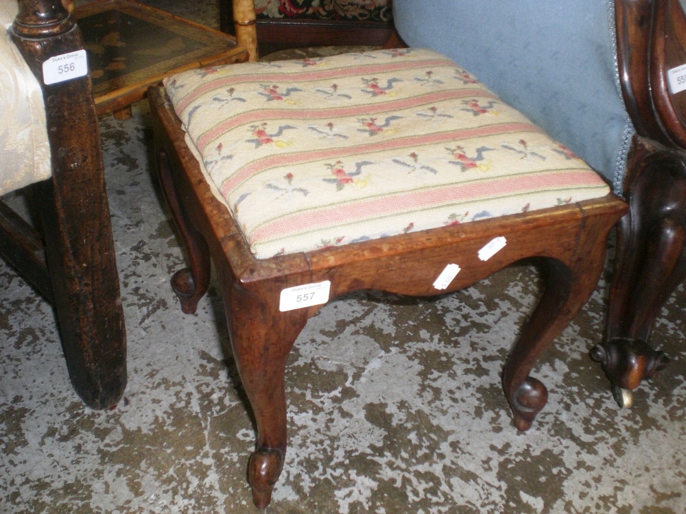 A 19th century rosewood footstool on cabriole legs with needlework top