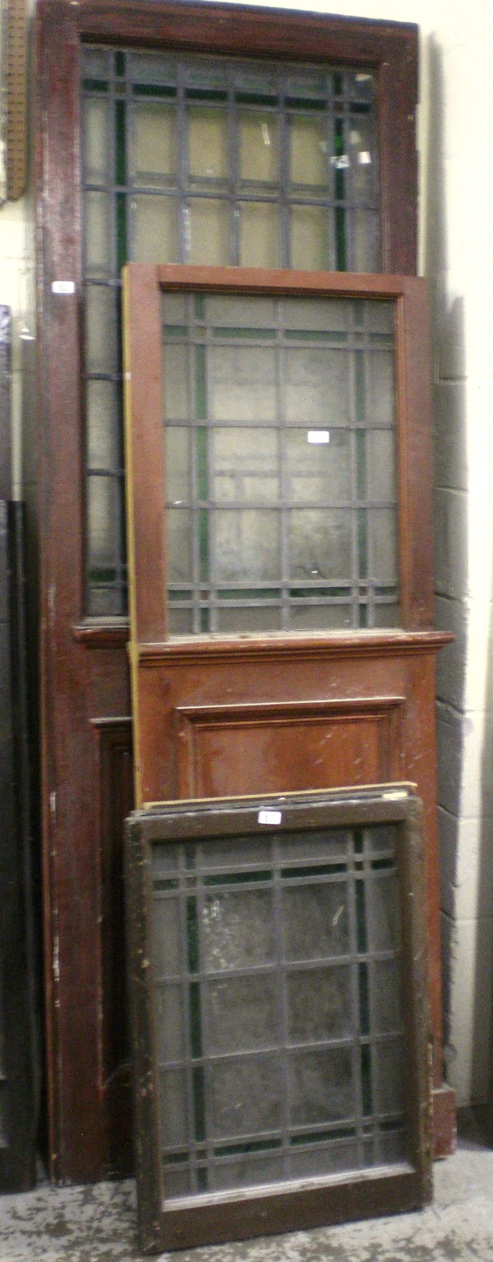 A collection of doors and panels with clear and green leaded panes