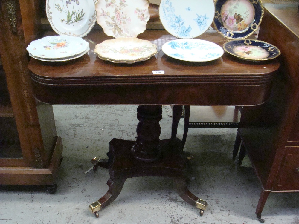 A Regency mahogany fold-over top tea table with polished brass cap castors