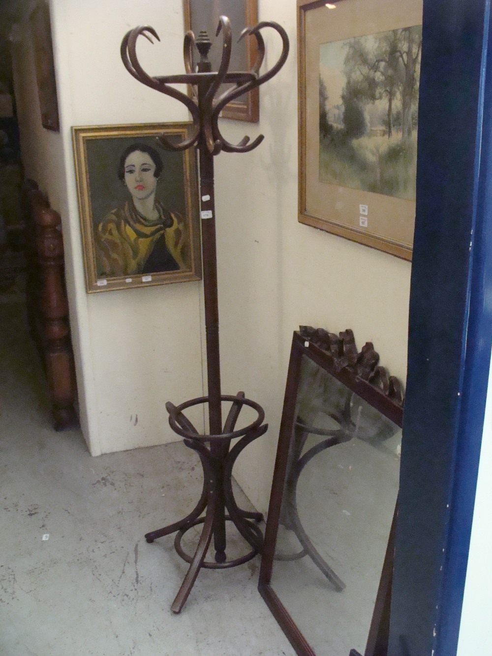 A Bentwood hat stand and a mirror with stained wooden frame with tied ribbon decoration